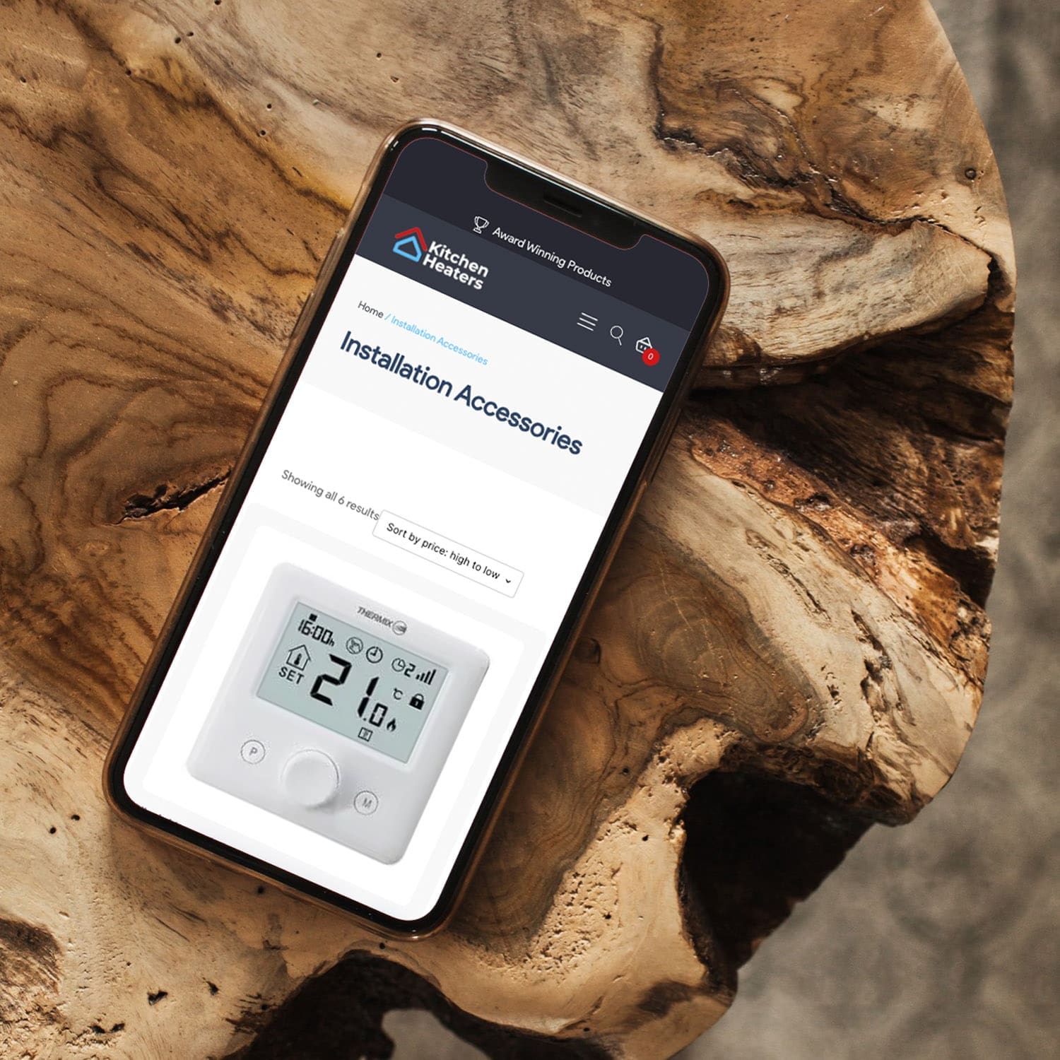 Smartphone displaying an online store page for kitchen installation accessories, placed on a wooden surface.